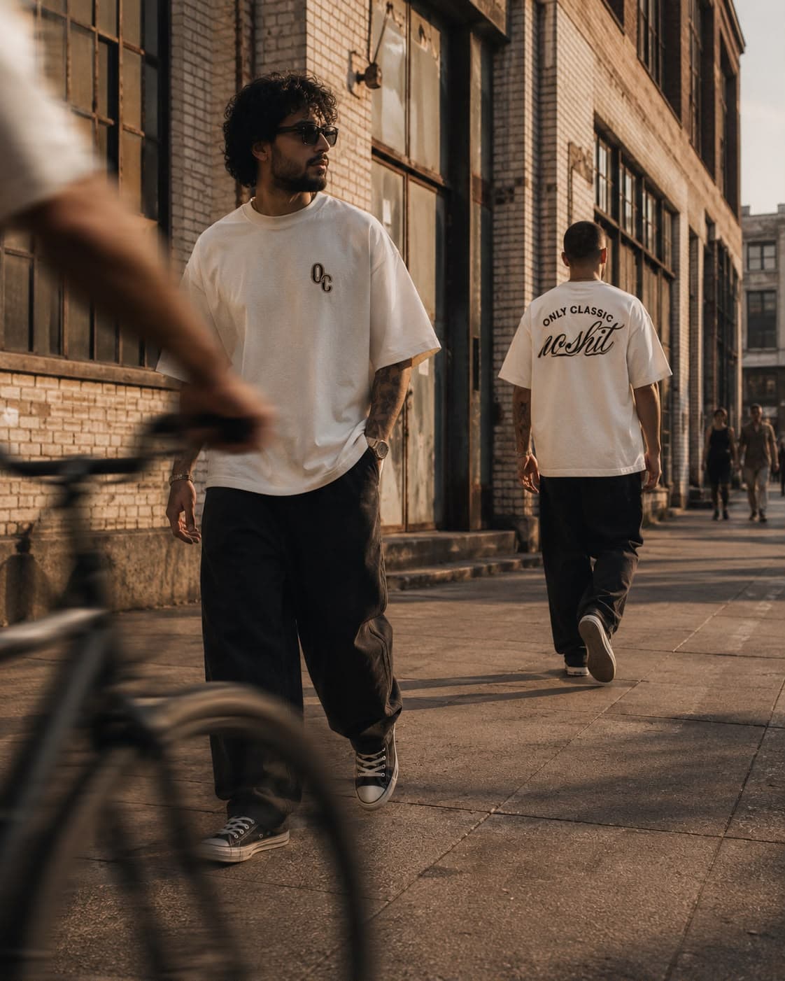 Modelo de costas em rua de tijolos ao entardecer, vestindo a camiseta off-white No Shit